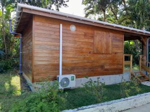 a small wooden building with a fan in the yard at Studio LAVANDES in Lamentin