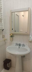 a bathroom with a white sink and a mirror at Sun Terrace Sorrento in Sorrento +25 photos