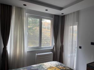 a bedroom with a bed and a large window at Forest Panorama Luxury Apartment in Velingrad +11 photos