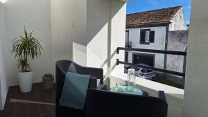 a balcony with chairs and a table and a fireplace at AzoreanStar Accommodations in Ponta Delgada