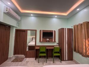 a room with a table and two chairs and a television at HOTEL SREE DURGA in Kolkata