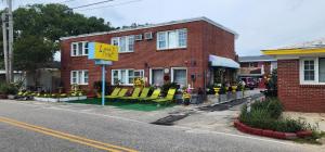 a red brick building with yellow chairs on the street at E & E Motel in Myrtle Beach
