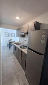 a kitchen with a refrigerator and a table in it at Acogedora Casa in El Sauzal