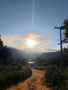a dirt road with the sun in the sky at Hospedaria Café Terra&Sabor in Palmeiras +4 photos