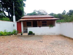 a small house with a red door and a brick courtyard at Hospedaria Café Terra&Sabor in Palmeiras