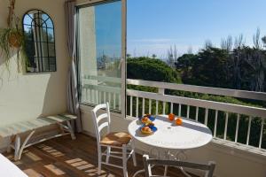 a balcony with a table and chairs and a window at Vacances au port in Saint-Cyprien-Plage +8 photos