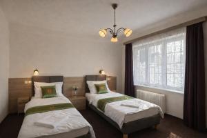 a bedroom with two beds and a window at Penzion u Fouska in Chodov