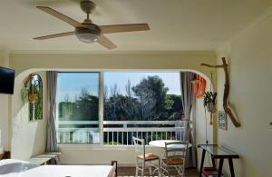 a living room with a ceiling fan and a balcony at Vacances au port in Saint-Cyprien-Plage