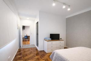 a bedroom with a bed and a television on a dresser at Ana Rent Departamento Moderno, Equipado full ,en San Isidro punto medio Tigre River y Tecnopolis in Boulogne