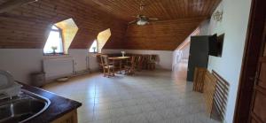 a kitchen with a table and chairs and a ceiling at Családfa Vendégház in Ságvár