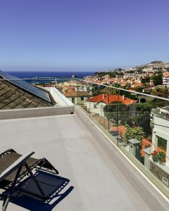 a balcony with a chair and a view of the city at CHC Rochinha Studio in Funchal
