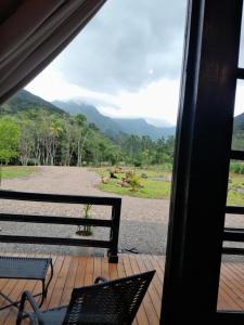 a view from the window of a porch with benches at Sombra do baú -Luar in Timbe do Sul