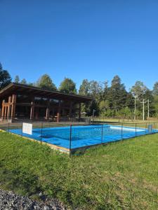 a swimming pool with a building in the background at Estancia del Sol in Putúe