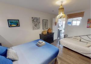 a bedroom with a blue bed and a chandelier at Sunset lodge in Bouzigues