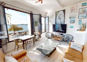 a living room with a view of the ocean at Sunset lodge in Bouzigues