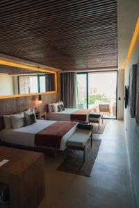 a hotel room with two beds and a balcony at Republica Pagana - Only Adults in La Paz