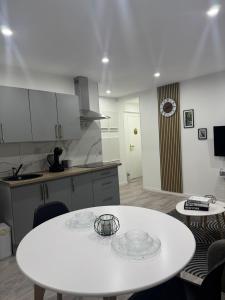a kitchen with a white table and two chairs at Appart' Cosy proche Mulhouse in Illzach +11 photos