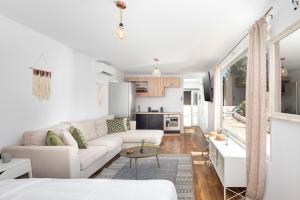 a white living room with a couch and a table at Elysian by the sea in Nisaki