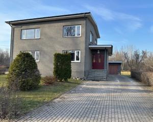 a house with a red door on a brick driveway at Kastan House in Mustvee