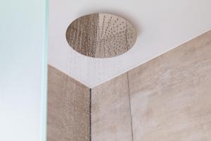 a round mirror on the wall of a bathroom at Elysian by the sea in Nisaki +31 photos