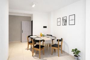 a white dining room with a table and chairs at Ana Rent Departamento Moderno, Equipado full ,en San Isidro punto medio Tigre River y Tecnopolis in Boulogne