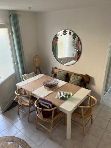 a dining room table with chairs and a mirror at Les Moussaillons, plage à pieds in Jullouville-les-Pins