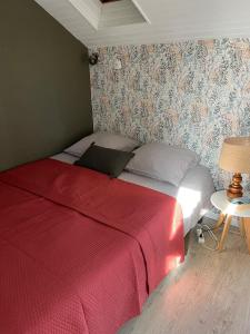 a bedroom with a bed with a red blanket at Les Moussaillons, plage à pieds in Jullouville-les-Pins +11 photos