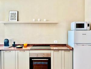 a kitchen with a white refrigerator and a microwave at Canaryislandshost l Bruma in Famara +25 photos