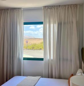 a bedroom with a bed and a window with a view at Canaryislandshost l Bruma in Famara