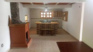 a kitchen with a stove and a table in a room at La Casa de Blue in Guarne