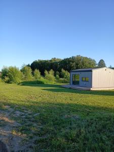 a small house in a field next to a field at Elenos sodyba in Puorai +29 photos