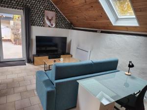 a living room with a blue couch and a table at le nid du calice in Abreschviller