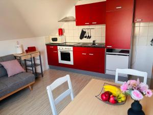a kitchen with red cabinets and a table with a bowl of fruit at Špirala place - near city center, free parking in Bled +8 photos