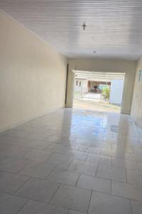 an empty room with a tile floor and a large window at Loft Farol in Pântano Grande
