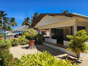a house on the beach with trees and bushes at Hotel Pousada Cachalote in Coruripe