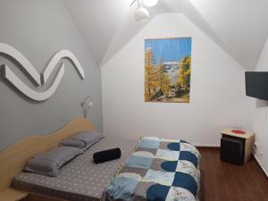 ein Schlafzimmer mit einem Bett und einem Gemälde an der Wand in der Unterkunft LaCoco in Buşteni