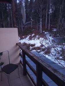 Eine Terrasse mit einem Stuhl und Schnee auf dem Boden in der Unterkunft LaCoco in Buşteni