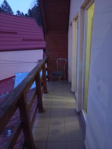 ein Balkon eines Hauses mit einem Stuhl darauf in der Unterkunft LaCoco in Buşteni + 14 Fotos