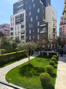 a park with a tree in the middle of a city at Nebula Apartments in Tirana
