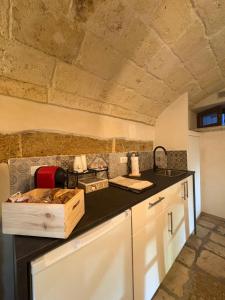 a kitchen with white cabinets and a black counter top at Il Cuore di San Cipriano in Mesagne +2 photos