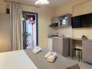 a kitchen with a bed with towels on it at INO Luxury Rooms in Paralia Katerinis