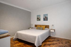 a bedroom with a bed with white sheets and yellow pillows at Ana Rent Departamento Moderno, Equipado full ,en San Isidro punto medio Tigre River y Tecnopolis in Boulogne