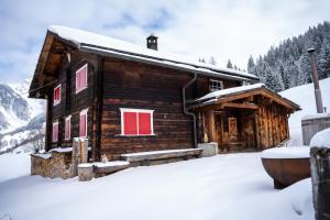 a log cabin with red doors in the snow at  