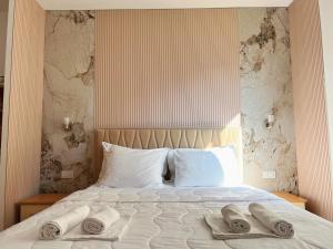 a bedroom with a bed with two towels on it at Apartments Fat e Jet - Pool & Breakfast in Ulcinj