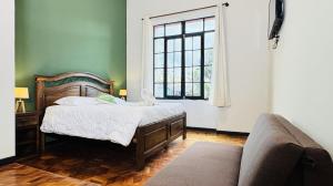 a bedroom with a bed and a couch and a window at 1825 Hotel in La Paz +59 photos