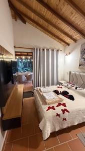 a bedroom with a bed with red bows on it at Condominio Entre Bosques Cabaña 9 in Piedecuesta