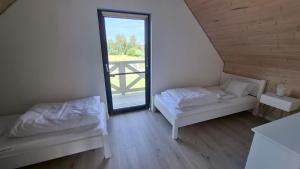 a room with two beds and a large window at Jantarovnia in Jantar