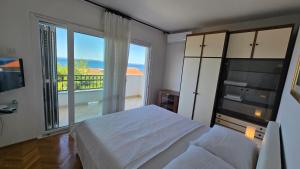 a bedroom with a bed and a large window at Apartments Buljan in Kožino