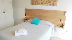 a bedroom with a white bed with blue pillows at San Jose Termas in Federación