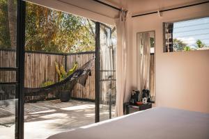 a bedroom with a view of a deck at La Negra Surf Hotel in Nosara